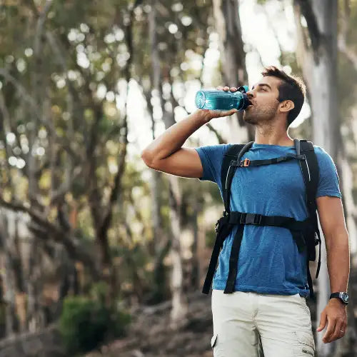 Blue water bottle with black strap and handle, likely made of plastic or metal.