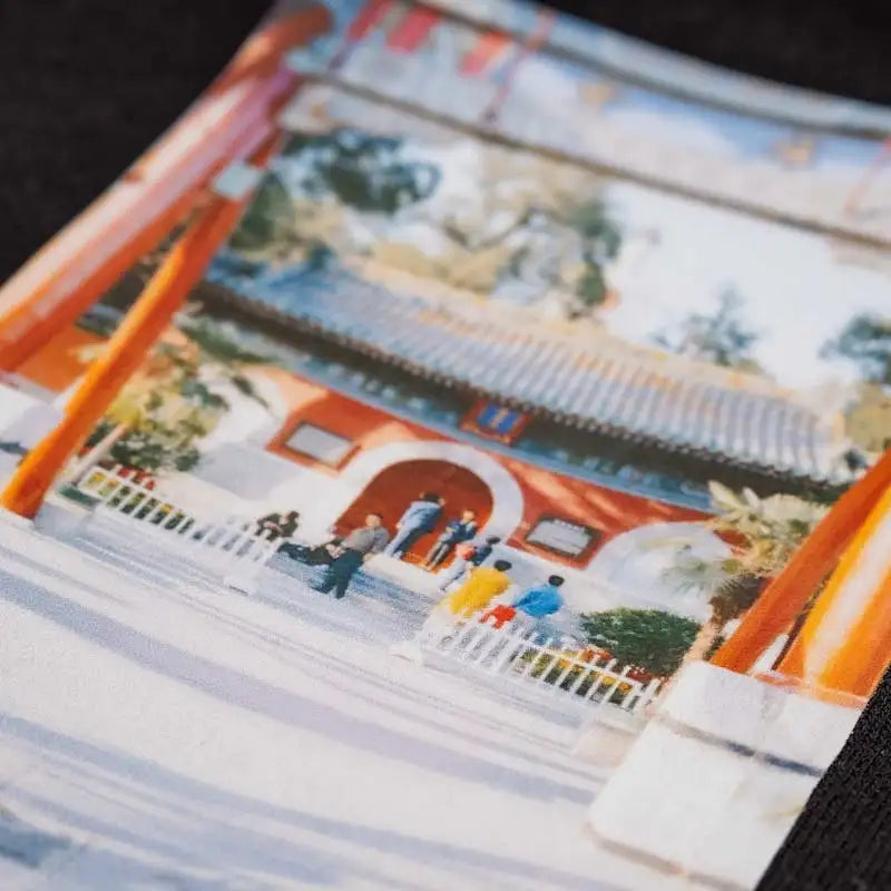 Orange and white striped fabric wallet chain with a printed design of people in front of an asian-style building.
